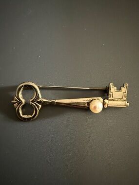 vintage silver-tone brooch shaped like a skeleton key